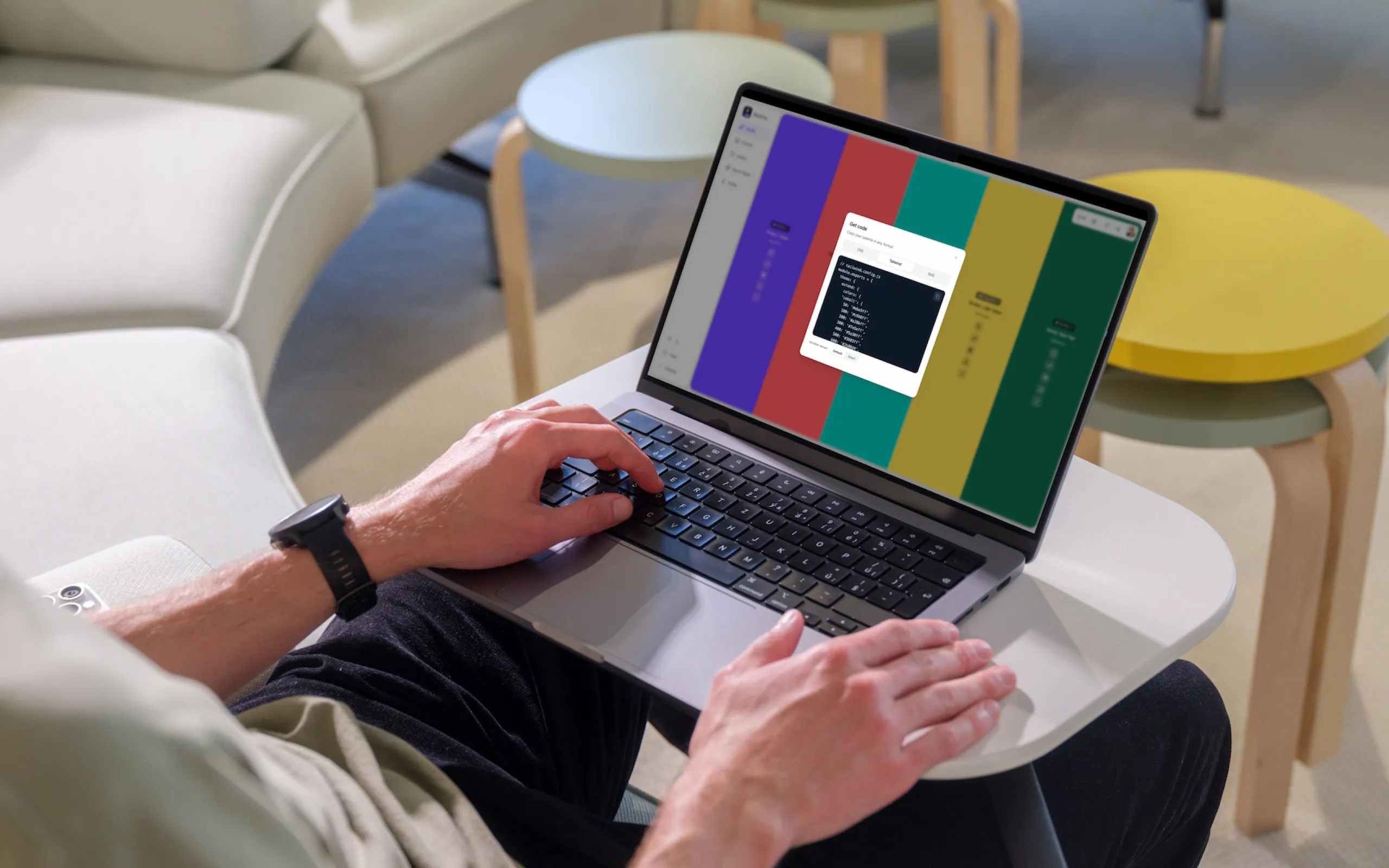 Someone using Paletta on a laptop in a lounge chair, with the palette view and an open panel on screen.